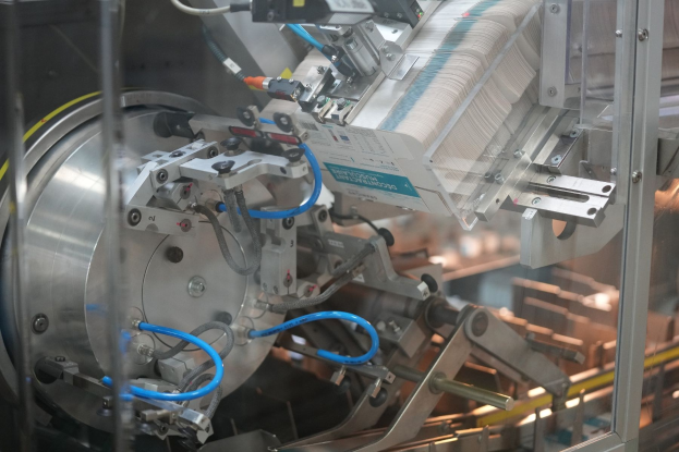 Automatisierte Verpackungssystemmaschine auf einem Fabriktisch mit leicht unscharfen Hintergrundobjekten.