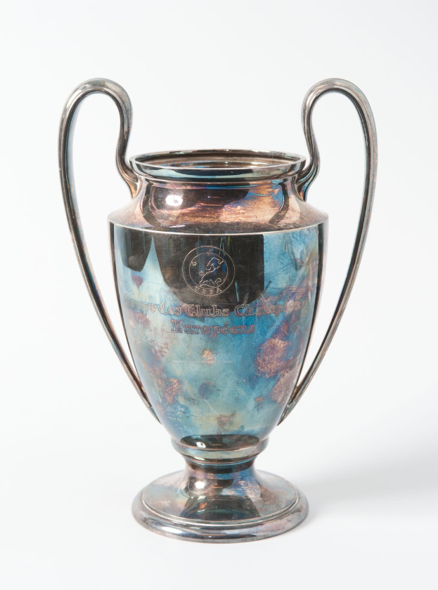 Der UEFA-Champions-League-Pokal, ein stählerner Becher mit zwei Griffen und einem blauen und silbernen Farbschema, der mit 'UEFA Champions League' beschriftet ist.