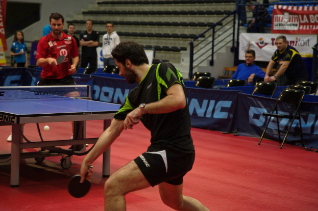 Eine Gruppe von Menschen in verschiedenen Farben, darunter schwarz, weiß und blau, versammelte sich um einen Tisch mit einem Spiel im Gange, mit Stühlen und einer Treppe im Hintergrund.