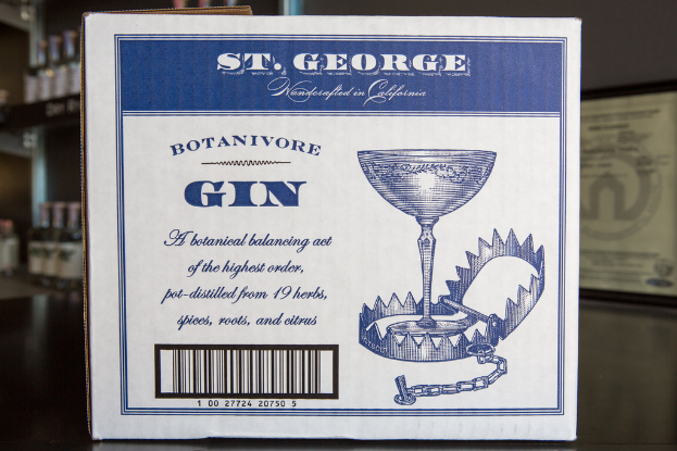 Ein Plakat mit Text wird vor Regalen mit vielen Flaschen gezeigt.