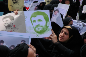 Eine Gruppe iranischer Frauen in schwarzer Kleidung, einige mit Brille, halten Fotos des Präsidenten Mahmoud Ahmadinejad während einer Demonstration in Tehran hoch.