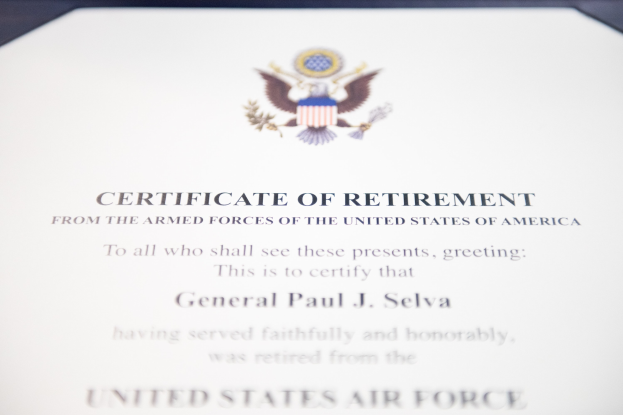 Rahmenurkunde der United States Air Force mit blauer Einfassung, die ein zentrales Sternemblem innerhalb eines Lorbeerkranzes und die Aufschrift 'Retirement' auf einem Banner zeigt.