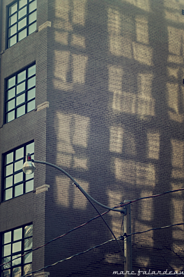 Ein Gebäude mit Glasfenstern auf der linken Seite und einem Lichtmast unten.