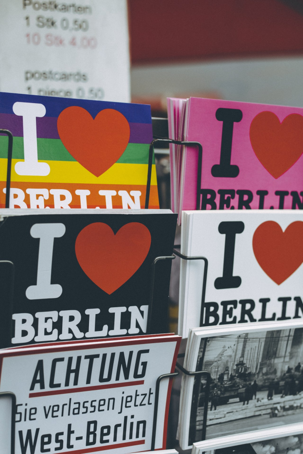 Ein Displayständer mit Büchern und Postern, auf denen der Text 'Ich liebe Berlin' steht, vor einem sanft unscharfen Hintergrund.