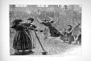 Eine Schwarz-Weiß-Radierung zeigt Kinder beim Ballspielen in einer Turnhalle, zwei Mädchen in der Mitte halten Stöcke und unten steht Text.