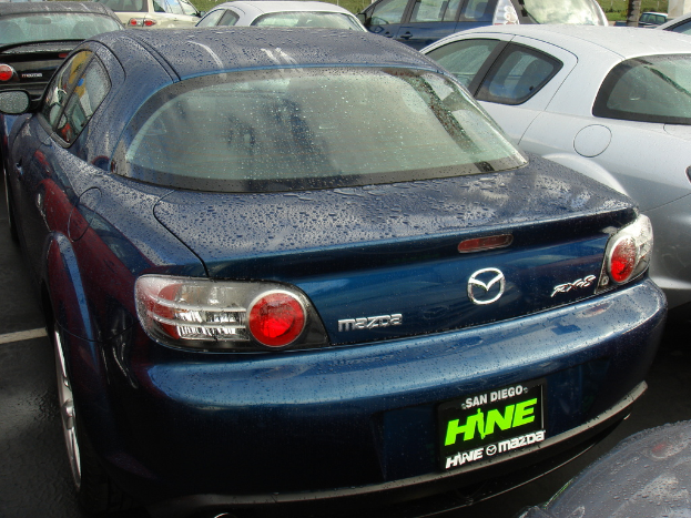 Mehrere Autos auf einer Straße mit einem Schild unten mit Text.