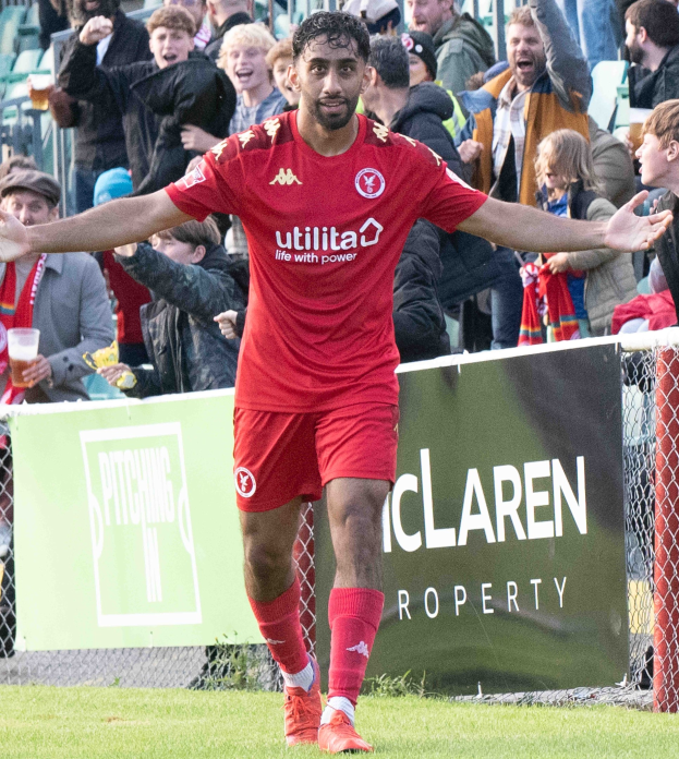Ein Fußballer in roter Uniform rennt mit ausgestreckten Armen auf einem Feld, umgeben von Zuschauern, mit einem "Middlesbrough FC v Swansea City - Sky Bet Championship"-Schild im Hintergrund.