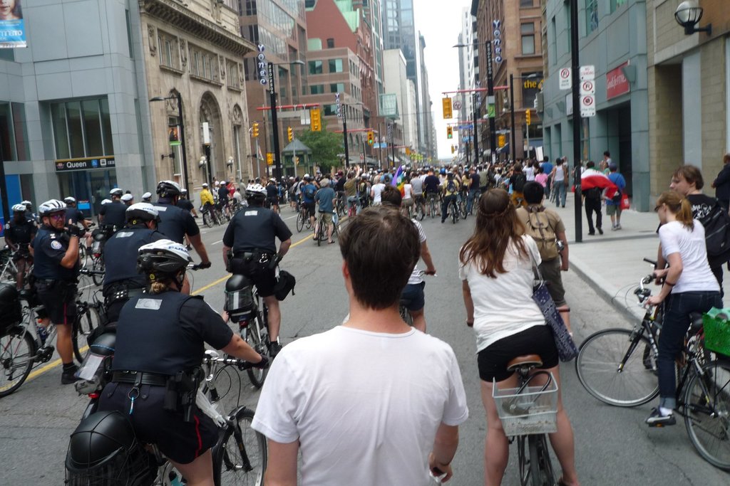 Gebäude und einige Fahrradfahrer auf einer Straße.