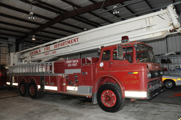 Ein Feuerwehrauto steht in einem großen Lagerhaus mit Deckenbeleuchtung.