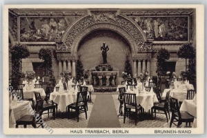 Ein altes Schwarz-Weiß-Foto eines Berliner Restaurants mit Tischen, Stühlen, Blumenvasen, einer Statue, Skulpturen und Pflanzen an den Wänden sowie Text am unteren Rand.