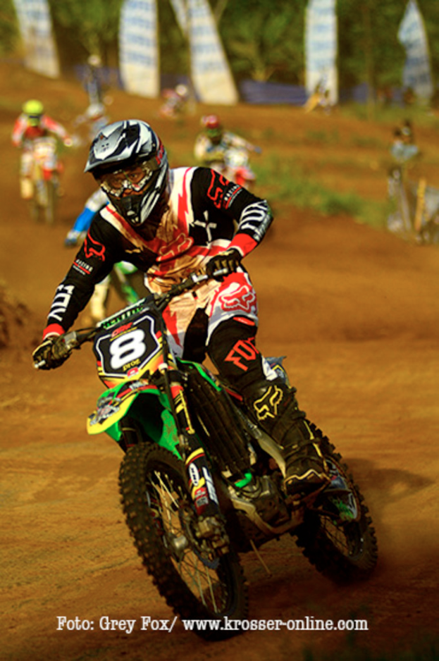 Mehrere Motorradfahrer mit Helmen rennen, mit Text unten im Bild angezeigt.