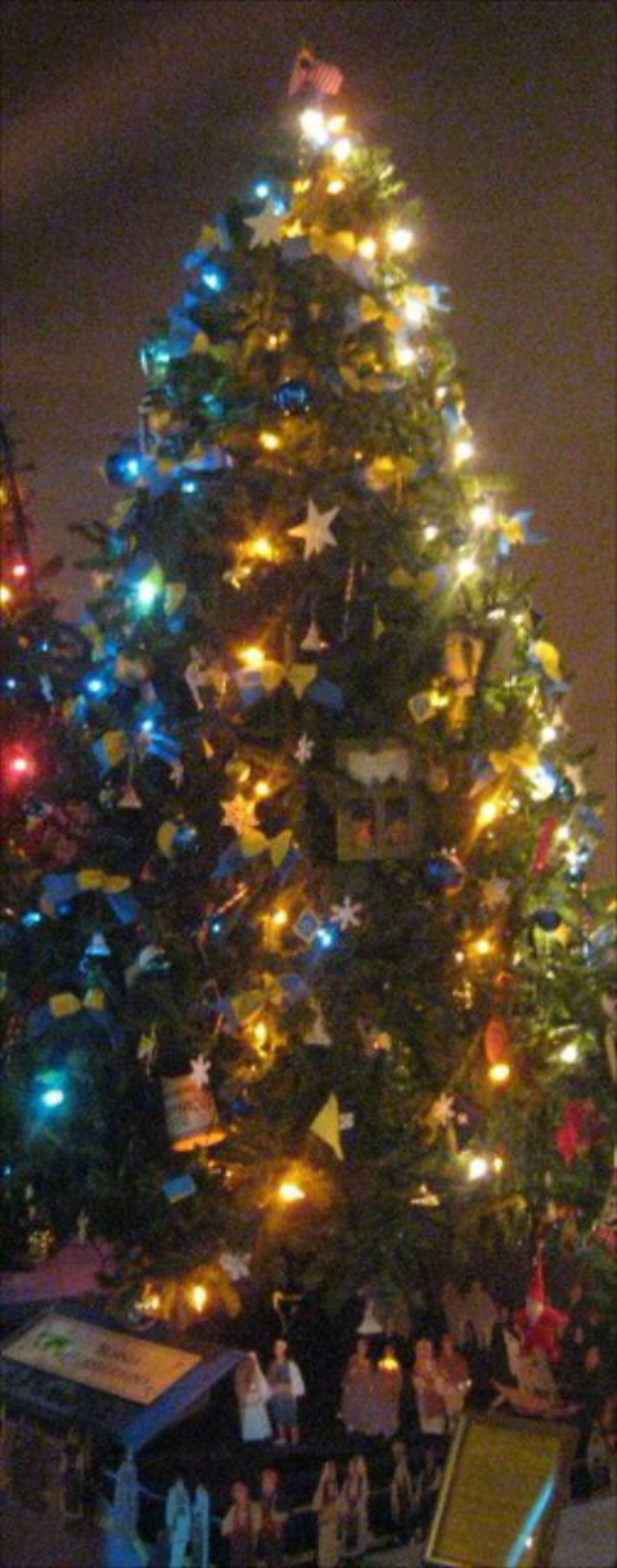 Ein geschmückter Weihnachtsbaum mit Statuen von Menschen darauf.