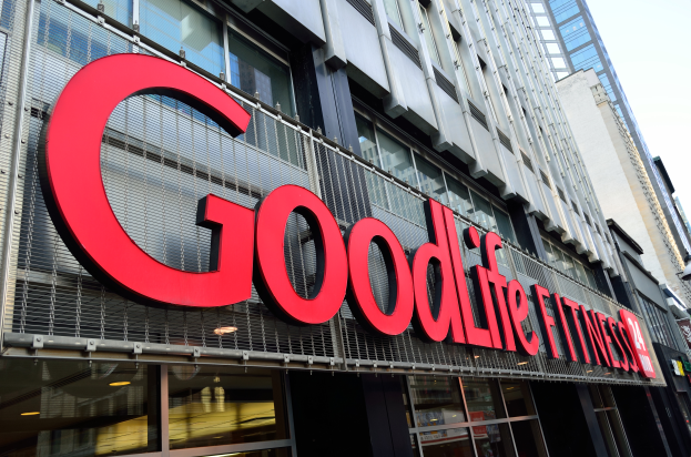 Ein Goodlife Fitness Studio in New York City mit Glaswänden und einem Namensschild, umgeben von anderen Gebäuden unter einem sichtbaren Himmel.