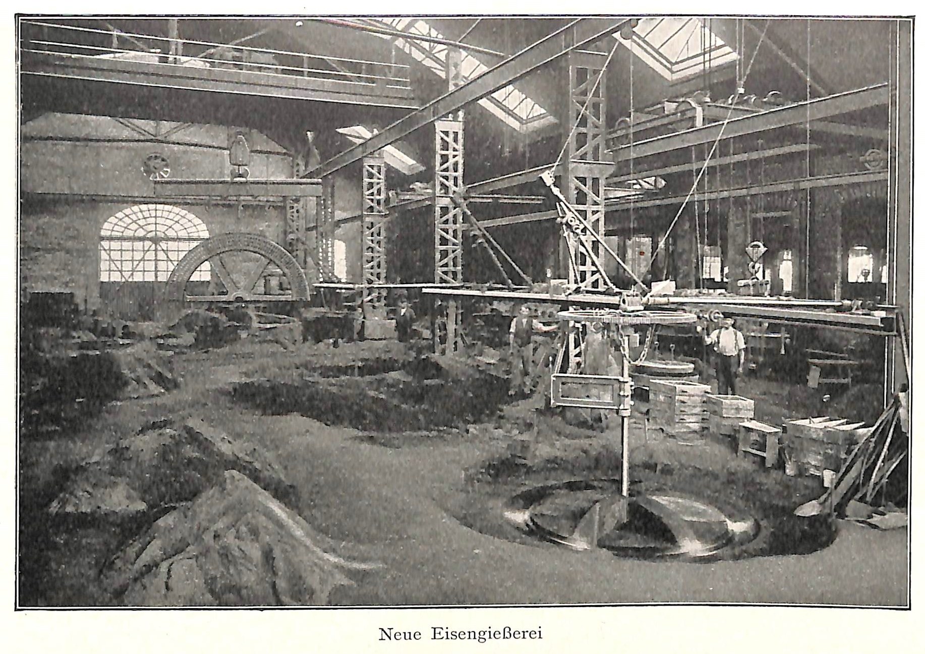 Altes Schwarz-Weiß-Foto einer Fabrik mit Arbeitern, die Maschinen bedienen, umgeben von Metallstangen und -pfosten, beschriftet mit "Neue Eisengießerei, die erste Fabrik Deutschlands."