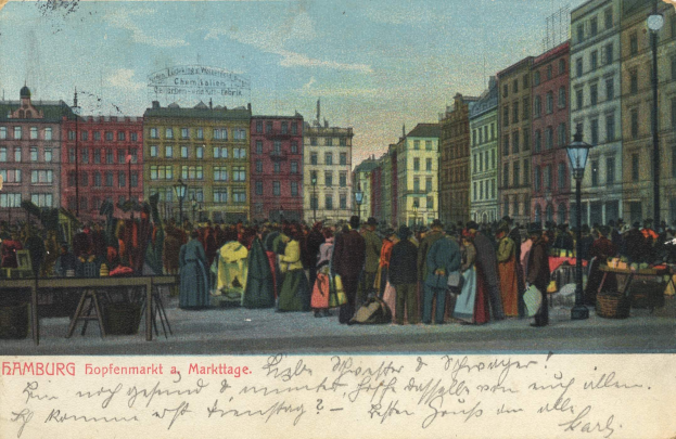 Schwarz-weiß-Postkarte eines belebten Hamburger Marktes mit Menschen, Tischen voller Waren, Straßenlaternen, Schildern, Gebäuden und einem bewölkten Himmel; Text unten.