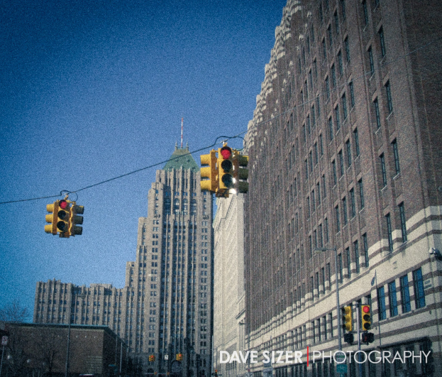 Mehrere Verkehrsampeln auf Masten vor Gebäuden.