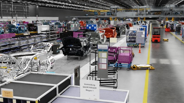 Eine große Volkswagen-Montageband mit zahlreichen Fahrzeugen in der Produktion, Metallstrukturen an den Seiten, einer Wand im Hintergrund und Deckenbeleuchtung.