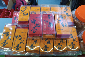 Ein Tisch mit verschiedenen Lebensmitteln und verpackten Waren während eines chinesischen Neujahrsfests, mit einer Person im Hintergrund.