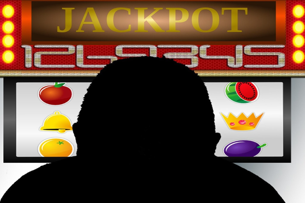 Ein Mann spielt ein Online-Spielautomaten-Spiel mit "Jackpot" angezeigt, umgeben von einer Tafel mit Text und Obstbildern.