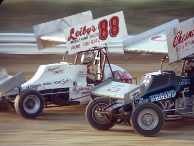 Mehrere Autos fahren auf einer Straße mit einer Sicherheitsbarriere im Bild, mit einem unscharfen Hintergrund.