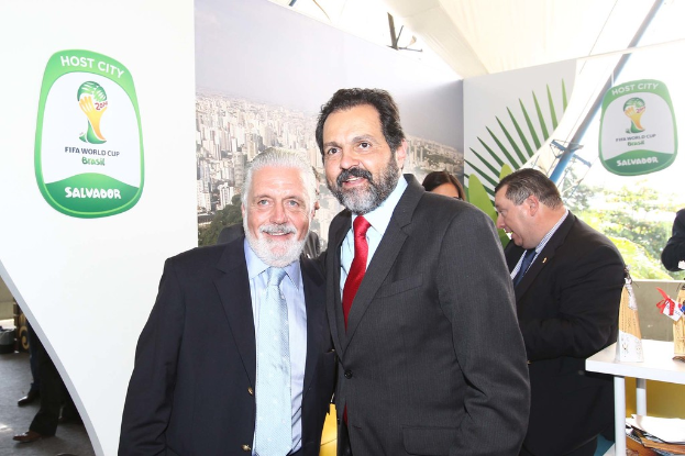 Eine Gruppe von Menschen, die mit einigen lächelnden Gesichtern und einem FIFA-Weltmeisterschaftsposter im Hintergrund steht.