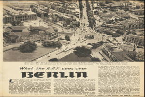 Schwarz-weißes Foto einer alten Zeitungsseite mit einem Stadtansicht-Bild, das Gebäude, Bäume und Fahrzeuge zeigt, begleitet von Text.