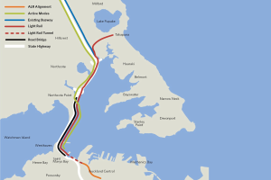 Eine detaillierte Stadtkarte mit einer roten Linie, die die geplante Bahnroute markiert, einschließlich Haltestellen und der Umgebung, mit Text, der Routen Details bereitstellt.